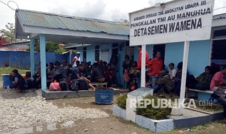 Warga menunggu pesawat Hercules milik TNI AU di Pangkalan TNI AU Manuhua Wamena, Jayawijaya, Papua, Rabu (25/9/2019).