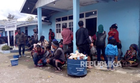 Warga menunggu pesawat Hercules milik TNI AU di Pangkalan TNI AU Manuhua Wamena, Jayawijaya, Papua, Rabu (25/9/2019).