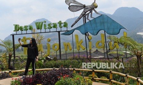 Wisatawan berswa foto di obyek wisata Kafe Sawah yang dikelola Badan Usaha Milik Desa (BUMDes) Pujon Kidul di Pujon, Kabupaten Malang, Jawa Timur, Kamis (26/9/2019).