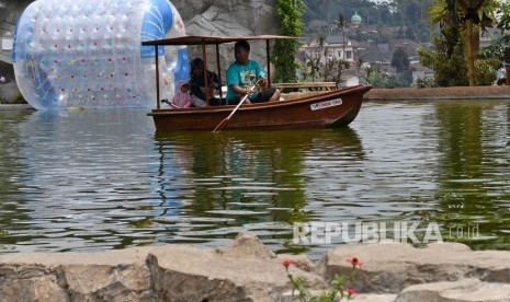 Sejumlah wisatawan mengendarai perahu di obyek wisata Kafe Sawah yang dikelola Badan Usaha Milik Desa (BUMDes) Pujon Kidul di Pujon, Kabupaten Malang, Jawa Timur.