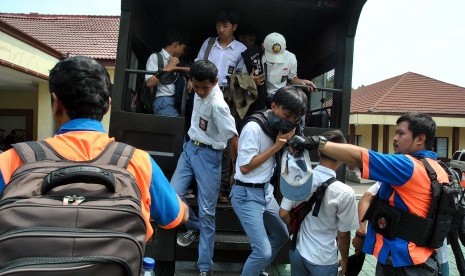 Anggota Satgas Pelajar Kota Bogor menurunkan sejumlah pelajar SMK di halaman Mako Polresta Bogor Kota, Kapten Muslihat, Kota Bogor, Jawa Barat, Senin (30/9/2019).