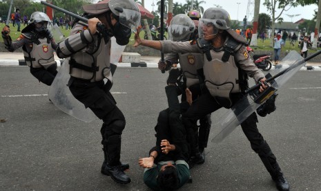 Petugas kepolisian terlibat bentrok dengan mahasiswa (tengah) saat unjuk rasa menolak RUU KUHP dan UU KPK hasil revisi di Kantor DPRD Jambi, Senin (30/9/2019).