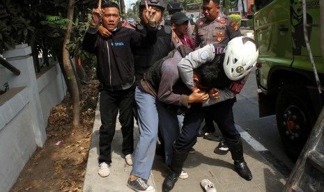 Polisi mengamankan sejumlah pelajar yang turun dari mobil truk saat hendak mengikuti aksi demo, di Bekasi, Jawa Barat, Senin (30/9/2019). 