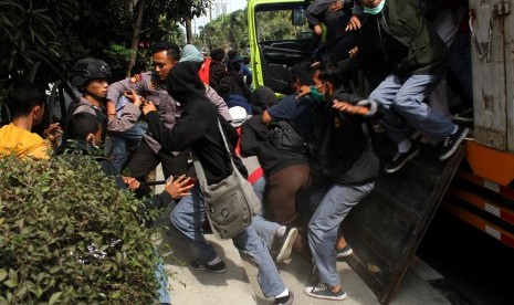 Polisi berusaha menghadang pelajar yang turun dari mobil truk saat hendak mengikuti aksi demo, di Bekasi, Jawa Barat, Senin (30/9/2019). 