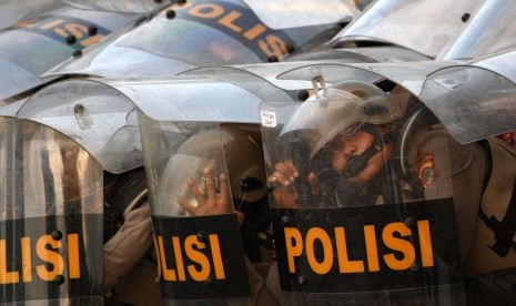 Sejumlah polisi berlindung dengan tameng dari lemparan batu saat kericuhan dalam unjuk rasa di Jalan Gatot Subroto, dekat kompleks Parlemen, Jakarta, Senin (30/9/2019).