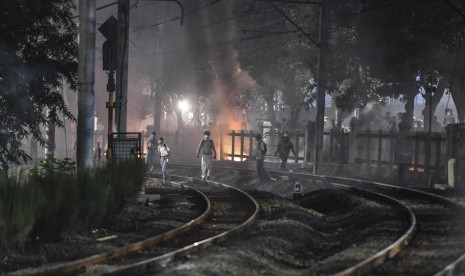 Pelajar dan mahasiswa berjalan di sepanjang rel kereta api saat melakukan aksi unjuk rasa di belakang gedung MPR/DPR, Jalan Tentara Pelajar, Jakarta, Senin (30/9/2019). 