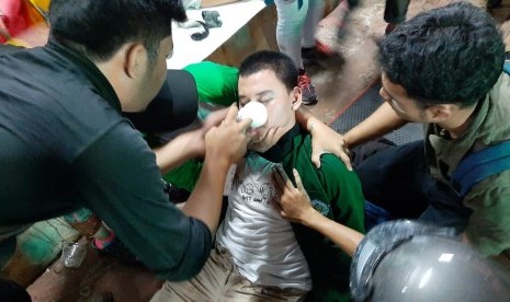 Mahasiswa peserta demonstrasi di sekitar Kompleks Parlemen Senayan diberikan pertolongan pertama oleh relawan tim medis di Pos Polsi di Depan Hotel Sultan, Jakarta, Senin (30/9).