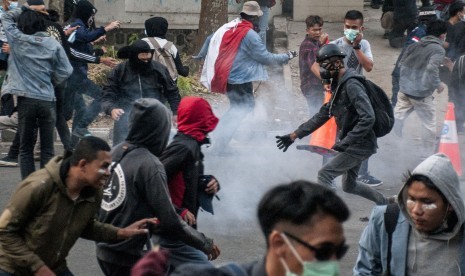 Mahasiswa dan pelajar bentrok dengan petugas kepolisian usai unjuk rasa di depan gedung DPRD Jawa Barat, Bandung, Jawa Barat, Senin (30/9/2019).