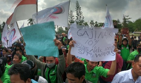 Massa Konfederasi Serikat Buruh Sejahtera Indonesia (KSBSI) membawa poster berisi tuntutan saat unjuk rasa tarif BPJS Kesehatan di Kantor DPRD Provinsi Jambi, Jambi, Senin (30/9/2019). 