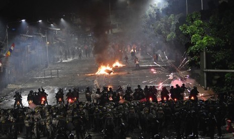 Polisi melakukan barikade saat menghalau massa pengunjuk rasa di Jalan Pejompongan Raya, Jakarta Pusat, Senin (30/9/2019) malam.