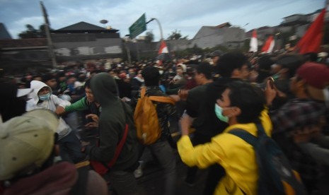 Sejumlah mahasiswa menghalau massa yang terlibat bentrok dengan polisi saat aksi unjuk rasa di depan gedung Parlemen, Jakarta, Senin (30/9/2019).