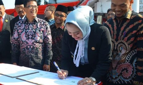 Bupati Karawang Cellica Nurrachadiana bersama Ketua KPU Karawang Miftah Farid dan jajaran lainnya, saat menandatangani naskah perjanjian hibah daerah (NPHD) untuk Pilkada 2020 mendatang, Selasa (1/10).