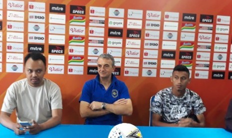 Pelatih Arema FC, Milomir Seslija (tengah) dan pemain Rivaldi Bauwo (kanan) memberikan keterangan pers terkait persiapan pertandingan melawan PSM Makassar di Kantor Arema FC, Kota Malang, Selasa (1/10). 