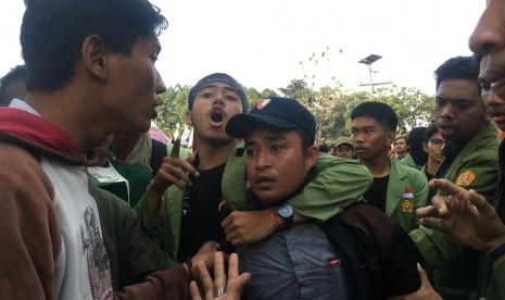 Pencopet telepon genggam mahasiswa UNJ saat aksi mahasiswa berlangsung di Jalan Gatot Subroto, Jakarta Pusat, Selasa (1/10).