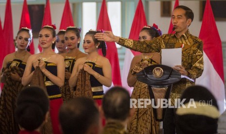 Presiden Joko Widodo (kanan) memberikan sambutan pada peringatan Hari Batik Nasional 2019 di Pura Mangkunegaran, Solo, Jawa Tengah, Rabu (2/10/2019). 