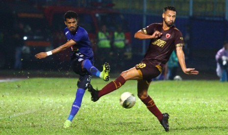 Pesepak bola PSM Makassar, Raphael Maitimo (kanan) berusaha menghalangi bola yang ditendang pesepak bola Arema FC, Alfin Tualasamony (kiri) dalam pertandingan Liga I di Stadion Kanjuruhan, Malang, Jawa Timur, Rabu (2/10/2019). 