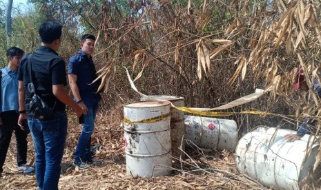 Tim Tipiter Satreskrim Polres Karawang, menyelidiki belasan drum tak bertuan diduga berisi limbah cair B3 yang dibuang di hutan milik Perhutani, Kamis (3/10).