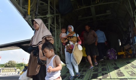 Para pengungsi akibat kerusuhan Wamena turun dari Pesawat Hercules C-130 TNI AU saat transit di Lanud Iswahjudi Magetan, Jawa Timur, Kamis (3/10/2019).