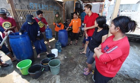 Warga mengantre untuk mendapatkan bantuan pembagian air bersih di Desa Tanjung Pasir, Kabupaten Tangerang, Banten.