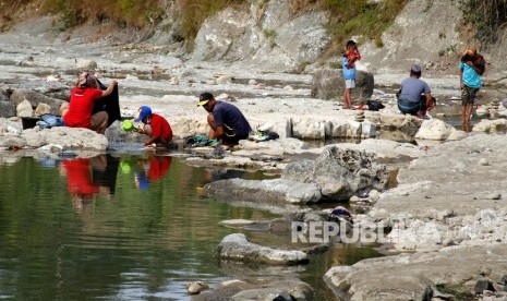 Warga mencuci pakaian di aliran Sungai Cileungsi, Bogor, Jawa Barat, Senin (7/10/2019).