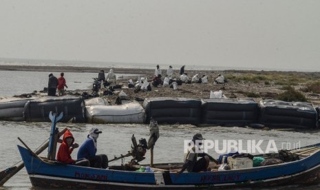 Nelayan Karawang Korban Tumpahan Minyak akan Diberi Beras. Nelayan melintas di sekitar lokasi terdampak tumpahan minyak (Oil Spill) dari sumur Pertamina Hulu Energi Off Shore North West Java (PHE ONWJ) di Pesisir Pantai Bungin, Karawang, Jawa Barat. 