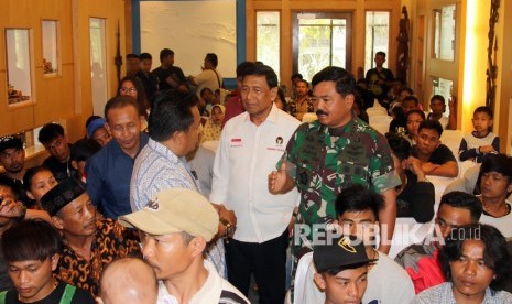 Menko Polhukam Wiranto (tengah) didampingi Panglima TNI Marsekal Hadi Tjahjanto (kanan) berbincang dengan pengungsi Wamena dan Ilaga di Timika, Mimika, Papua, Rabu (9/10/2019).