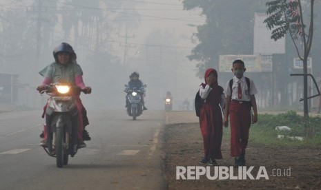 Pelajar dan warga beraktivitas di jalan raya di Jambi yang penuh kabut asap. ilustrasi