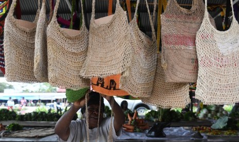 Pedagang menawarkan tas noken yang merupakan tas tradisional Papua.