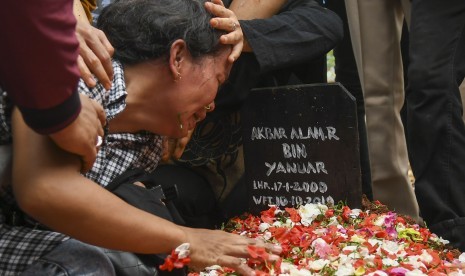 Ibu Akbar Alamsyah, Rosminah (kiri) menangis saat prosesi pemakaman korban demo ricuh Akbar Alamsyah di Taman Pemakaman Umum (TPU) kawasan Cipulir, Kebayoran Lama, Jakarta, Jumat (11/10/2019). 