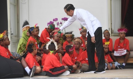 Presiden Joko Widodo berjabat tangan dengan anak-anak perwakilan siswa SD di Jayapura dan Asmat, Papua, di Istana Merdeka, Jakarta, Jumat (11/10/2019).