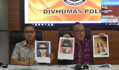 Karopenmas Divisi Humas Polri Brigjen Pol Dedi Prasetyo (kanan) menunjukkan foto tersangka pelaku dan barang bukti penikaman Menko Polhukam Wiranto saat konferensi pers di Mabes Polri, Jakarta, Jumat (11/10/2019). 