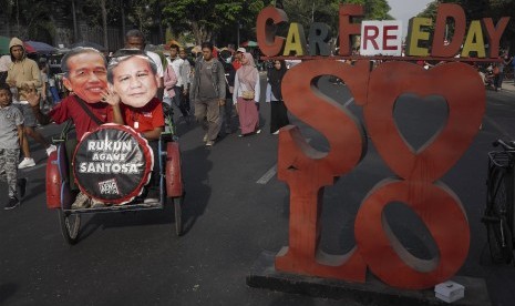 Warga memakai topeng bergambar peserta Pilpres 2019, Joko Widodo (kiri) dan Prabowo Subianto (kanan) saat aksi Rukun Agawe Santoso pada Hari Bebas Kendaraan Bermotor (HBKB) di Solo, Jawa Tengah, pada Oktober 2019 lalu. (ilustrasi)