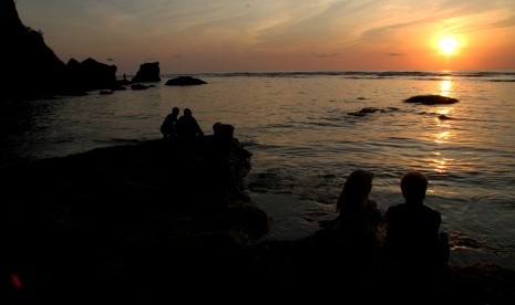 Wisatawan lokal dan asing menikmati panorama sunset di Pantai Uluwatu, Bali, Ahad (12/10/2019).