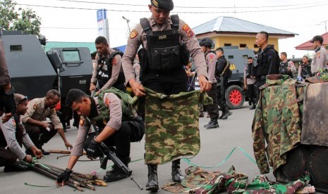 Petugas kepolisian menyita sejumlah atribut dan senjata tajam ketika membongkar Markas Komite Nasional Papua Barat (KNPB) di Timika, Papua, Senin (14/10/2019).