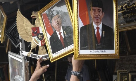 Pengunjung mengamati poster Presiden Joko Widodo dan Wakil Presiden terpilih Ma'ruf Amin di salah satu kios figura di Sriwedari, Solo, Jawa Tengah, Rabu (16/10/2019).