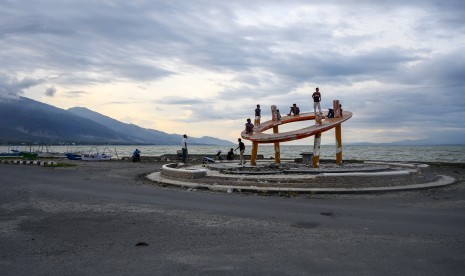 Sejumlah anak bermain di bekas Tugu Bumi yang rusak akibat tsunami di Pantai Taman Ria, Palu, Sulawesi Tengah, Rabu (16/10/2019).