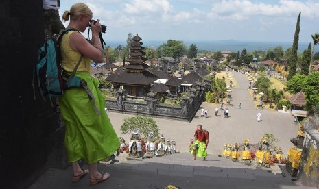 Wisatawan mancanegara memotret suasana kawasan Pura Besakih di Karangasem, Bali, Kamis (17/10/2019). Badan Pusat Statistik (BPS) mencatat kunjungan wisatawan mancanegara ke Indonesia naik 0,95 persen pada Juli 2020 