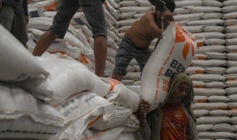 Pekerja memanggul karung beras Bulog untuk dipindahkan kedalam mobil box di Gudang Bulog Kelapa Gading, Jakarta, Jumat (18/10/2019).