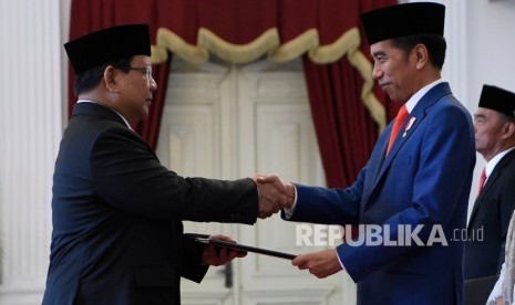 Presiden Joko Widodo (kanan) menyerahkan petikan keputusan kepada calon Menteri Pertahanan Prabowo Subianto (kiri) dalam rangkaian pelantikan jajaran menteri Kabinet Indonesia Maju di Istana Merdeka, Jakarta, Rabu (23/10/2019). 