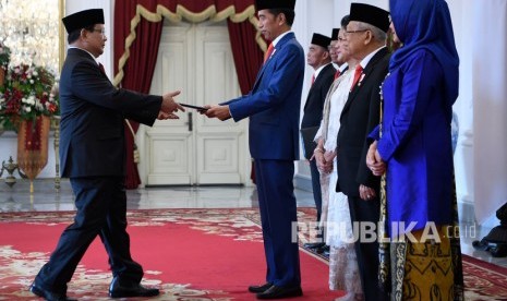 Presiden Joko Widodo (tengah) didampingi Ibu Negara Iriana Joko Widodo (ketiga kanan), Wakil Presiden Maruf Amin (kedua kanan) dan Ibu Wury Estu Handayani (kanan) menyerahkan petikan keputusan kepada calon Menteri Pertahanan Prabowo Subianto (kiri) dalam rangkaian acara pelantikan menteri Kabinet Indonesia Maju di Istana Merdeka, Jakarta, Rabu (23/10/2019).