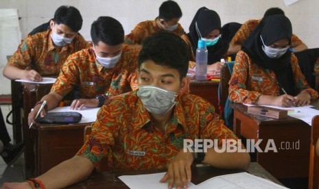 Siswa mengikuti pelajaran dengan mengenakan masker di SMAN 7, Malang, Jawa Timur, Rabu (23/10/2019). Beberapa sekolah di Malang saat itu diliburkan setelah ditemukannya ratusan siswa dan guru positif terjangkit atau menjadi pembawa bakteri difteri.