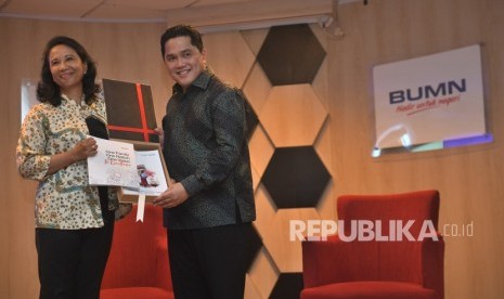 Menteri BUMN Erick Thohir (kanan) menerima buku laporan lima tahunan Kementerian BUMN dari mantan Menteri BUMN Rini Soemarno, saat serah terima jabatan di Kementerian BUMN, Jakarta, Rabu (23/10/2019).