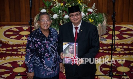 Menko Perekonomian Airlangga Hartarto (kanan) menerima buku memori jabatan Menko Perkonomian dari pejabat lama Darmin Nasution, dalam serah terima jabatan di Kantor Kemenko Perekonomian, Jakarta, Rabu (23/10/2019).