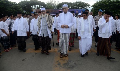 Plt Gubernur Aceh Nova Iriansyah (tengah) bersama rombongan ulama dan Forum Koordinasi Pimpinan Daerah (Forkopimda) memasuki lapangan saat menghadiri apel bersama peringatan Hari Santri Nasional di Banda Aceh, Aceh, Kamis (24/10/2019).