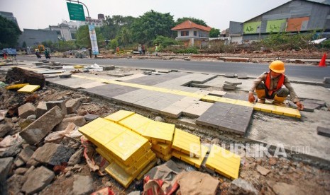 Pekerja melakukan pengerjaan proyek trotoar di kawasan Kemang, Jakarta Selatan, Jumat (25/10/2019). 