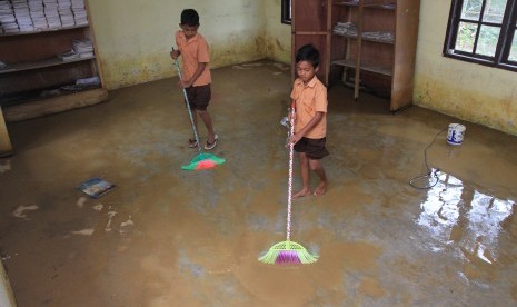 Siswa membersihkan kelas akibat banjir menggenangi Sekolah Dasar Negeri (SDN) Desa Alue Meuganda, Kecamatan Woyla Timur, Aceh Barat, Aceh, Jumat (25/10/2019). 