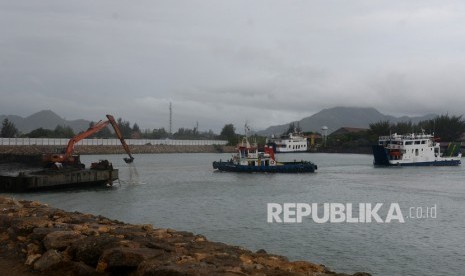 Kapal angkutan pulau KMP Pupuyu dan KMP BRR memasuki pelabuhan saat pekerja mengoperasikan ekskavator mengeruk kolam pelabuhan penyeberangan Ulee Lheue, Banda Aceh, Aceh, Ahad (2710/2019). 