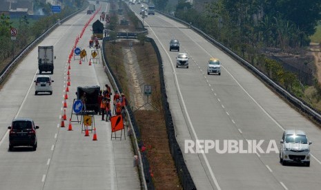 Pekerja melakukan perawatan jalan di tol Jombang-Mojokerto (Jomo) yang melintasi Desa Watudakon, Kecamatan Kesamben, Kabupaten Jombang, Jawa Timur, Senin (28/10/2019).