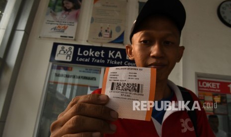 Calon penumpang menunjukan tiket KA lokal Walahar Ekspres di Stasiun Kramat, Jakarta, Senin (28/10).