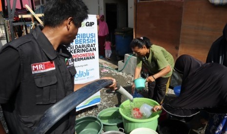 Relawan ACT Sulteng mengisi air bersih di ember-ember yang yang disediakan oleh pengungsi di kompleks Hunian sementara Di Kelurahan Mamboro Induk, Kota Palu